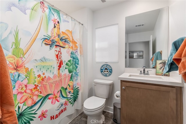 bathroom featuring vanity, toilet, and walk in shower