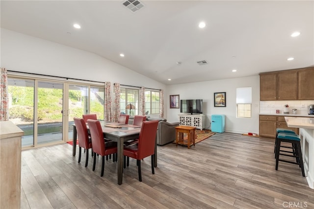 dining space featuring light hardwood / wood-style floors and vaulted ceiling