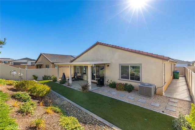 back of property featuring a lawn, central AC, and a patio