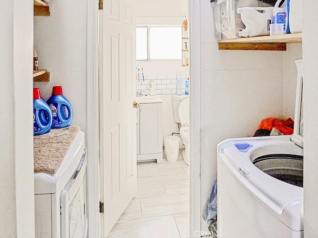 laundry area with sink, tile walls, and washer / clothes dryer