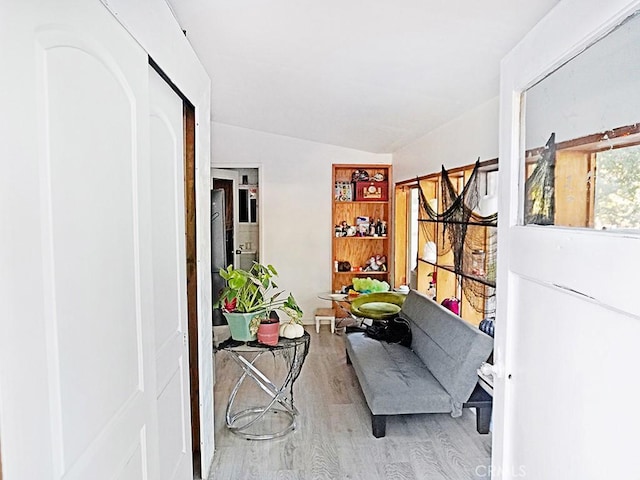 sitting room with hardwood / wood-style flooring and vaulted ceiling