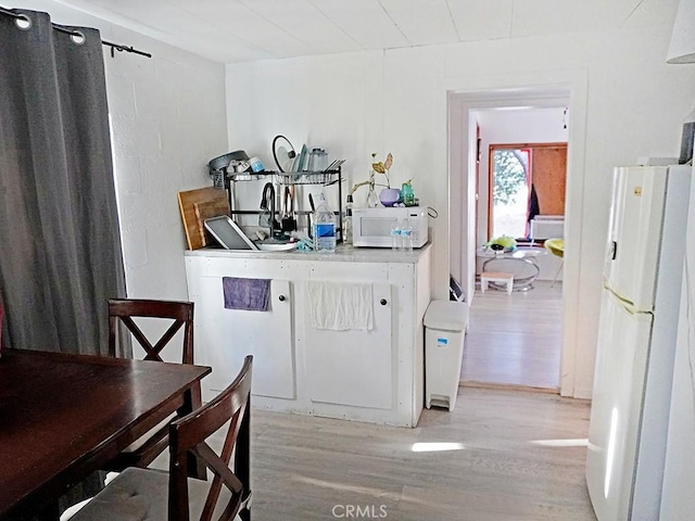 kitchen with light hardwood / wood-style floors and white appliances