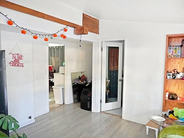 unfurnished room featuring vaulted ceiling with beams and light wood-type flooring