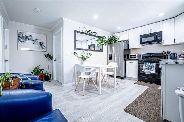 kitchen with white cabinets, black appliances, and ornamental molding