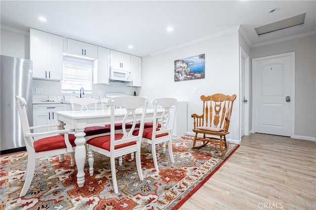 dining room featuring crown molding and light wood-type flooring