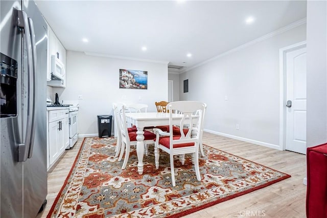 dining space featuring light hardwood / wood-style floors and crown molding