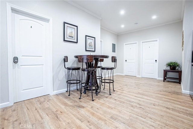 dining room featuring light wood-type flooring and ornamental molding