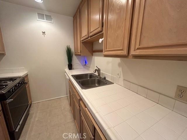 kitchen featuring black stove, tile countertops, and sink