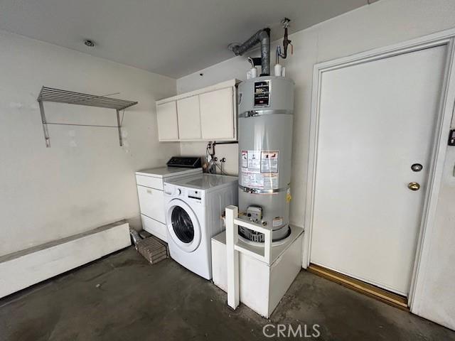 laundry room featuring washing machine and clothes dryer, secured water heater, and cabinets