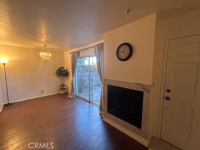 unfurnished living room featuring dark hardwood / wood-style floors and an inviting chandelier