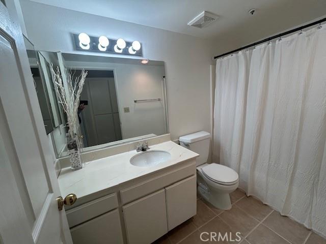 bathroom with tile patterned flooring, vanity, and toilet