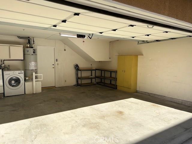 garage featuring secured water heater, washer and clothes dryer, and a garage door opener