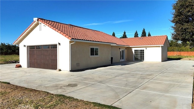 view of front of property featuring a garage, stucco siding, and a tiled roof