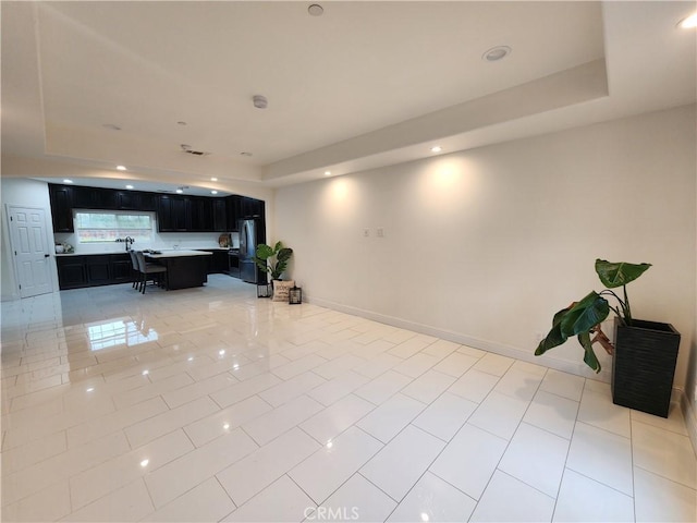 tiled living room featuring a raised ceiling