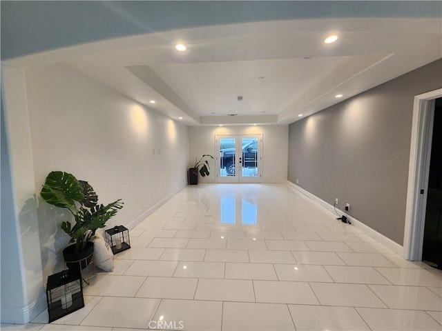 tiled spare room with french doors and a tray ceiling