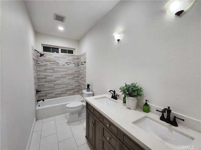 full bathroom featuring toilet, vanity, tile patterned flooring, and tiled shower / bath