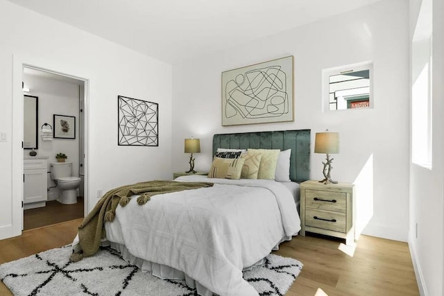 bedroom featuring ensuite bathroom and light wood-type flooring