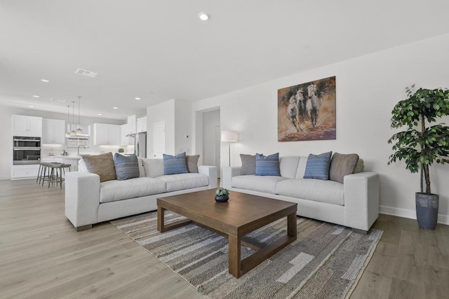 living room featuring sink and light hardwood / wood-style flooring