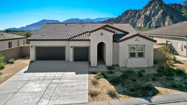 mediterranean / spanish-style house with a mountain view and a garage