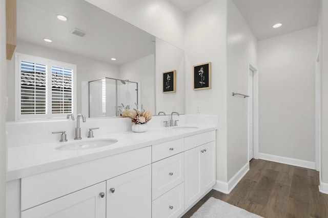 bathroom featuring vanity, wood-type flooring, and a shower with shower door