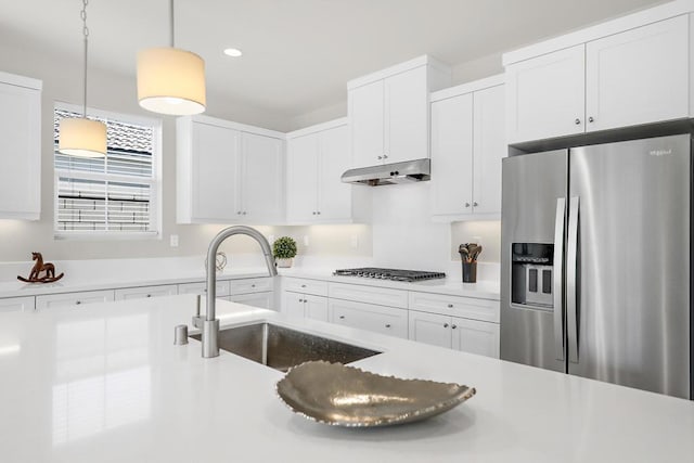 kitchen with stainless steel appliances, white cabinetry, hanging light fixtures, and sink