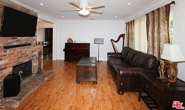 living room featuring a fireplace, ceiling fan, light hardwood / wood-style flooring, and ornamental molding