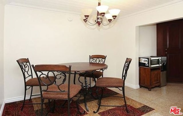 dining area with crown molding and an inviting chandelier