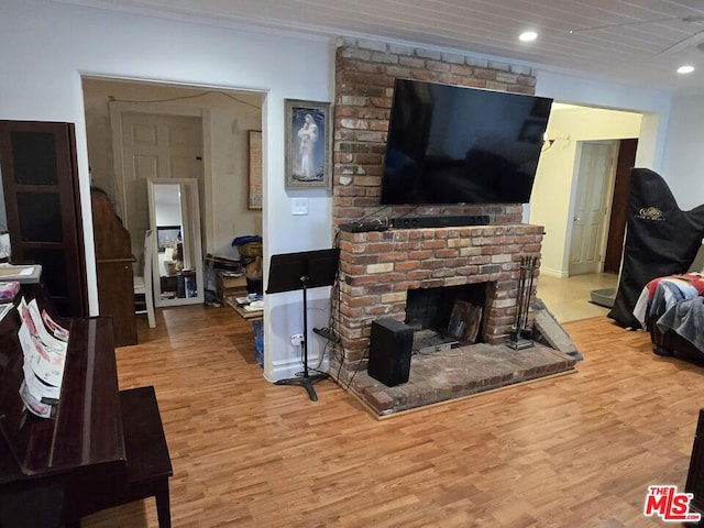 living room with a fireplace, light hardwood / wood-style flooring, and ornamental molding