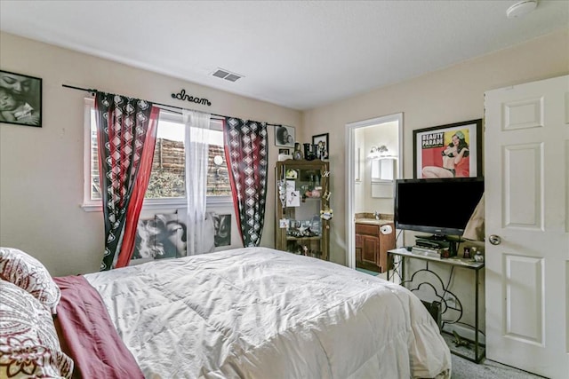 bedroom featuring connected bathroom and carpet floors