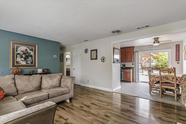 living room with ceiling fan and light hardwood / wood-style floors