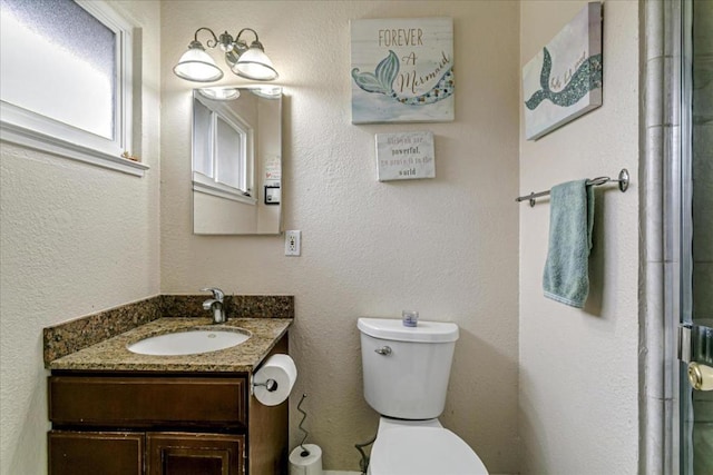 bathroom with vanity, toilet, and walk in shower