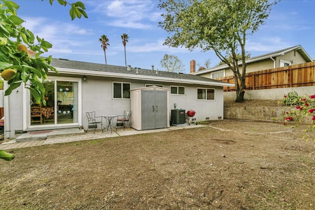 back of property featuring a shed and central air condition unit