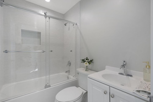 full bathroom featuring vanity, bath / shower combo with glass door, and toilet