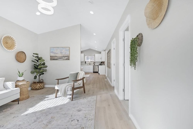 hall featuring vaulted ceiling and light hardwood / wood-style flooring