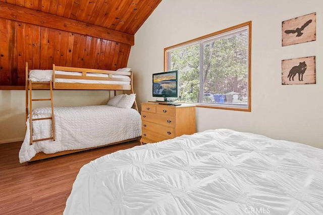 bedroom with lofted ceiling with beams, hardwood / wood-style floors, and wood ceiling