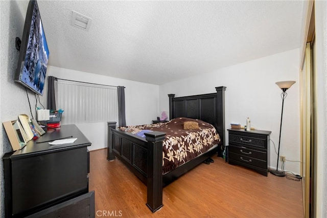 bedroom featuring hardwood / wood-style floors and a textured ceiling