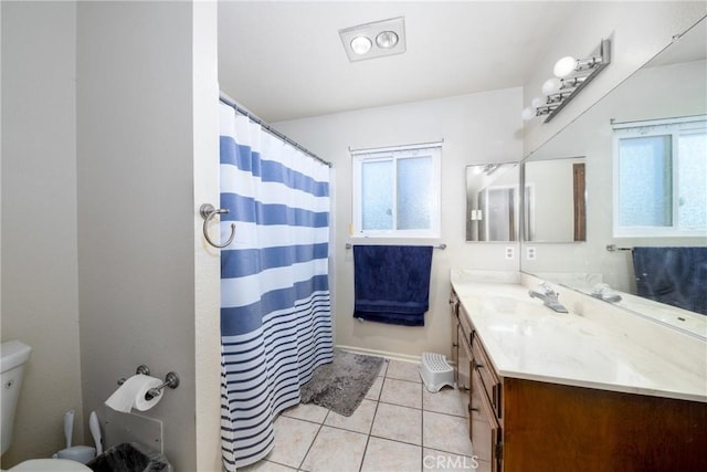 bathroom featuring tile patterned flooring, vanity, toilet, and curtained shower