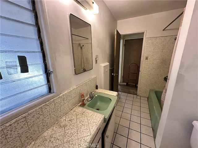 bathroom featuring tile patterned flooring, vanity, and tiled shower / bath combo