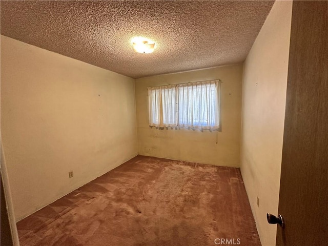 empty room featuring carpet and a textured ceiling