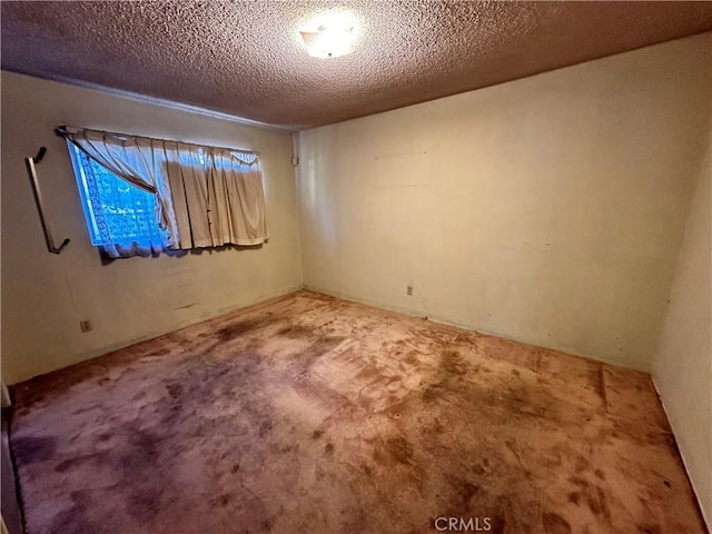 unfurnished room with carpet flooring and a textured ceiling