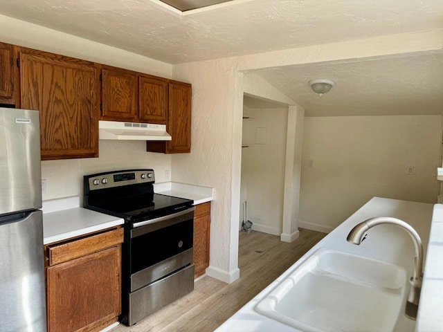 kitchen with stainless steel appliances, light hardwood / wood-style floors, and sink