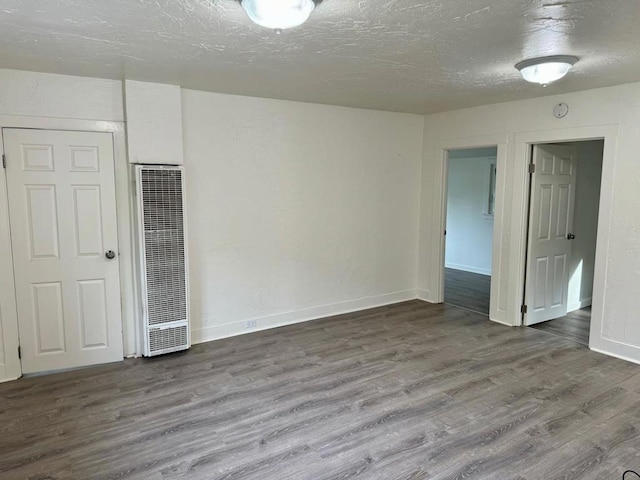 spare room featuring a textured ceiling and hardwood / wood-style floors