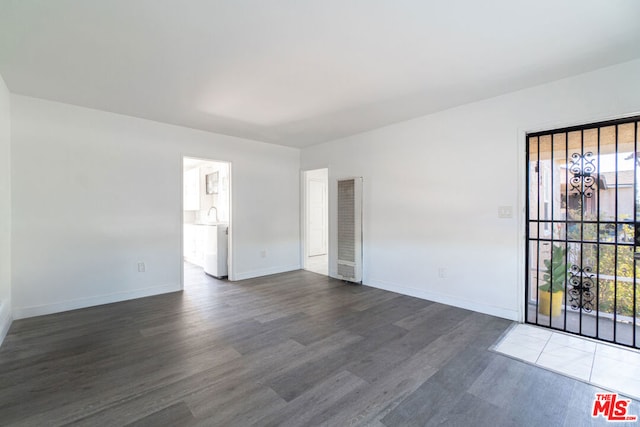 spare room featuring dark wood-type flooring, a healthy amount of sunlight, and sink