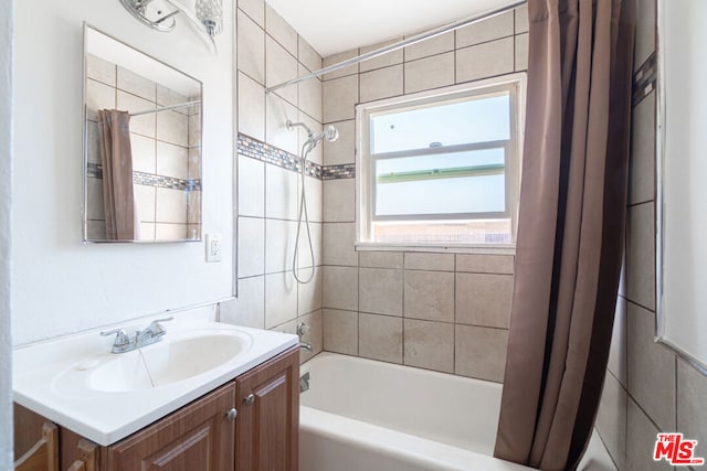 bathroom featuring vanity and shower / bathtub combination with curtain