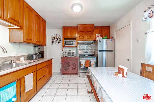 kitchen with sink, light tile patterned flooring, and stainless steel appliances