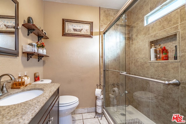 bathroom featuring tile patterned floors, vanity, toilet, and walk in shower