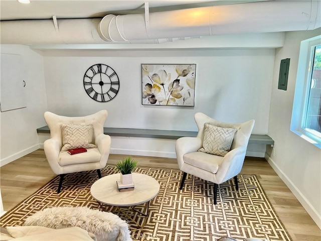 sitting room featuring electric panel and hardwood / wood-style flooring