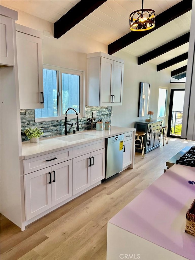 kitchen featuring beamed ceiling, white cabinets, stainless steel dishwasher, and sink