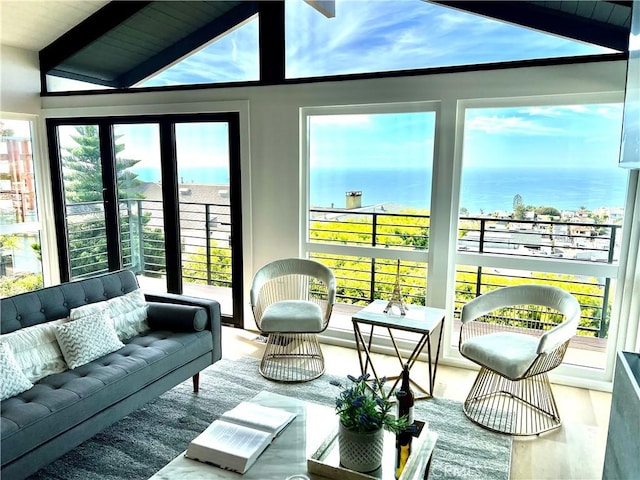 sunroom featuring lofted ceiling with beams and a healthy amount of sunlight