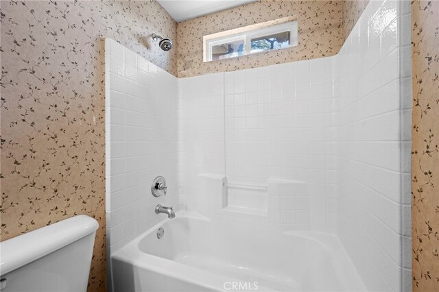 bathroom with shower / bathing tub combination and toilet